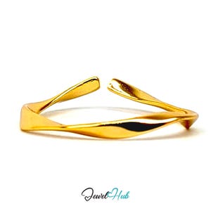 Peut inclure: Une bague ouverte dorée présentant un design de bande torsadée et fluide avec une surface polie et réfléchissante. La bague possède une ouverture sur le dessus, permettant un ajustement de la taille. Le texte Jewel Hub est imprimé en noir et bleu sarcelle.