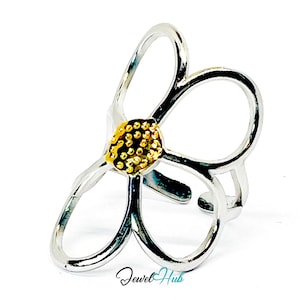 May include: A silver-colored ring in the shape of a flower with a gold-colored center. The ring has an open design with curved petals and a textured center. The Jewel Hub logo is visible at the bottom.