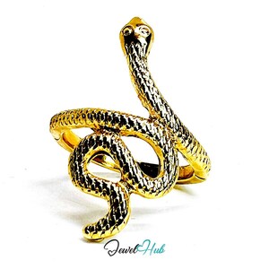 Op de afbeelding: Een goudkleurige ring in de vorm van een kronkelende slang met een gestructureerd, schubachtig oppervlak. De kop van de slang bevindt zich aan de bovenkant, terwijl het lichaam zich om de vinger wikkelt als ringband. Tekst Jewel Hub onderaan.
