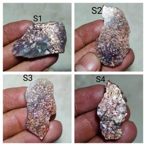 May include: Four irregular raw mineral specimens labelled S1, S2, S3, and S4. Each piece features a metallic, iridescent surface with copper, purple, and silver tones, displaying a crystalline, flaky texture with reflective, shimmering inclusions.