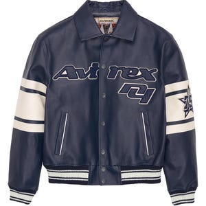 K&ouml;nnte beinhalten: Marineblaue Lederjacke mit wei&szlig;en Akzenten und dem Text "Avirex 74". Die Jacke hat einen Kragen, Druckkn&ouml;pfe und gestreifte B&uuml;ndchen und Saum. Wei&szlig;e Streifen verlaufen die &Auml;rmel hinunter.