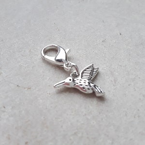 Charm de plata tibetana con forma de colibrí, cierre de pinza, marcador de puntada y cremallera.