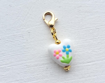 Ciondolo a clip a forma di cuore in porcellana con fiori rosa e blu e chiusura a moschettone, ideale come segnapunti, cerniera o ciondolo per agenda.