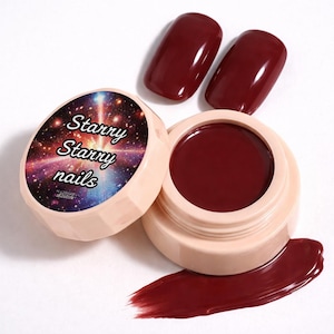 Pode incluir: Um pote de gel de unhas bordô com duas amostras de unhas correspondentes. A tampa do pote apresenta um design de galáxia estrelada com as palavras "Starry Starry nails". Uma amostra do gel é visível.