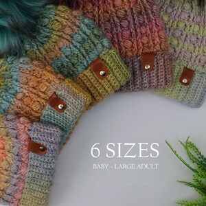 May include: A collection of six colorful knitted beanies in various shades of green, orange, purple, and blue. Each beanie has a brown leather tag with a silver button. The text "6 SIZES" and "BABY - LARGE ADULT" is displayed.