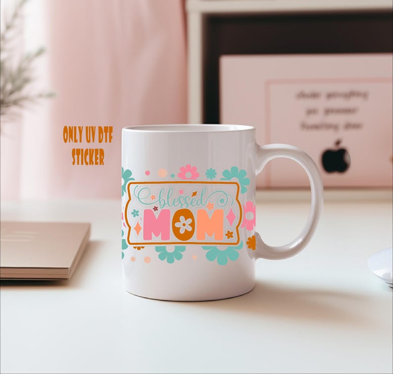 A white mug with a colorful design featuring the text "blessed mom" and various floral and geometric patterns.