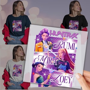 May include: T-shirts in navy, black, and white, each featuring a graphic design with the text "HUNTRAX" and the names "RUMI," "MIRA," and "ZOEY." The design includes illustrations of animated characters in vibrant colors.