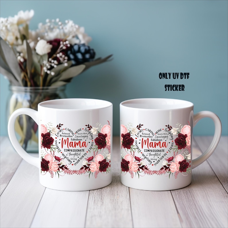 Two white ceramic mugs with floral designs and text printed on them, placed on a wooden surface against a blue background.