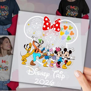 May include: A white graphic featuring Disney characters Pluto, Goofy, Donald Duck, Daisy Duck, Minnie Mouse, and Mickey Mouse. The design includes a red polka-dot bow, fireworks, and the text "Disney Trip 2026".