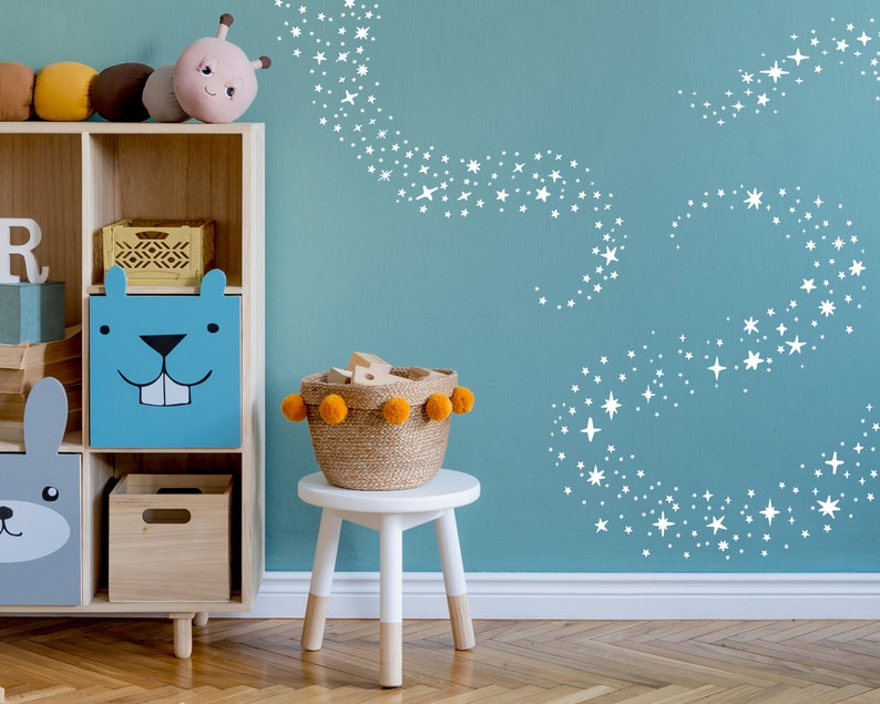 May include: A blue and white wooden storage box with a cartoon beaver face on the front. The box is on a wooden shelf with other storage boxes and toys. The wall behind the shelf is painted a light blue color and has a white star design.