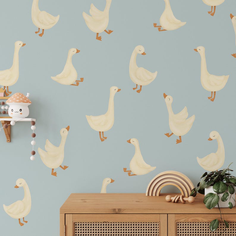 May include: A light blue background with a repeating pattern of white geese. The geese are in various positions, some are facing left, some are facing right, and some are in mid-flight. The geese are all outlined in brown and have a light brown beak.