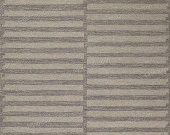 Peut inclure: Un tapis rectangulaire à motifs rayés. Le tapis présente des bandes alternées de beige clair et de gris, créant un aspect texturé et tissé. Le motif est symétrique, avec des rayures horizontales sur la surface du tapis.