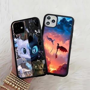 May include: Two black phone cases with dragon-themed designs. One case features a collage of dragon characters, while the other showcases dragons flying against a sunset sky. Both cases have a black border.