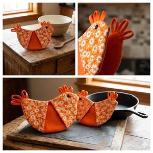 Op de afbeelding: Twee ovenwanten in de vorm van een kip met een levendig oranje en wit madeliefjespatroon op het lichaam, effen oranje vilten accenten en een zwart knoopoog. De wanten hebben een kam en staart gemaakt van lussen van oranje stof.