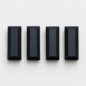 Puede incluir: Cuatro tiradores de armario rectangulares negros con un diseño facetado sobre un fondo blanco. Los tiradores tienen una estética moderna y geométrica, y probablemente están hechos de metal o un material similar.