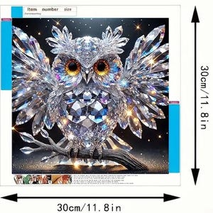 K&ouml;nnte beinhalten: Ein Diamant-Malset mit einer glitzernden Eule mit ausgebreiteten Fl&uuml;geln, die auf einem Ast sitzt. Das Kunstwerk ist 30 cm gro&szlig;. Der K&ouml;rper und die Fl&uuml;gel der Eule bestehen aus kristallartigen Facetten. Die Eule hat gro&szlig;e, goldene Augen.