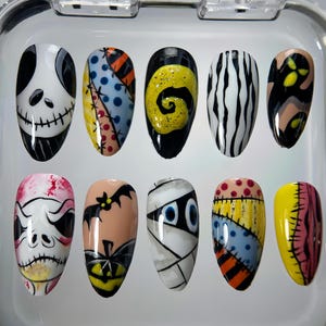 May include: A set of ten Halloween-themed false nails. Designs include Jack Skellington, patchwork, a yellow swirl, black and white stripes, a ghost, a skull, a bat and pumpkin, a mummy, and more patchwork.