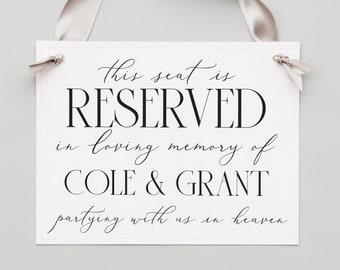 Może przedstawiać: Biały znak z czarnym tekstem, który brzmi: "This seat is RESERVED in loving memory of COLE & GRANT partying with us in heaven". Biała wstążka jest przywiązana do znaku.