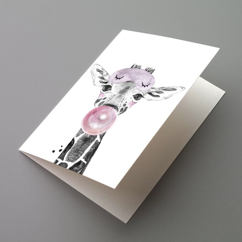 May include: A folded greeting card with a watercolour illustration of a giraffe wearing a lavender sleep mask and blowing a pink bubble. The giraffe's neck is black and white, with a pink bubblegum bubble.