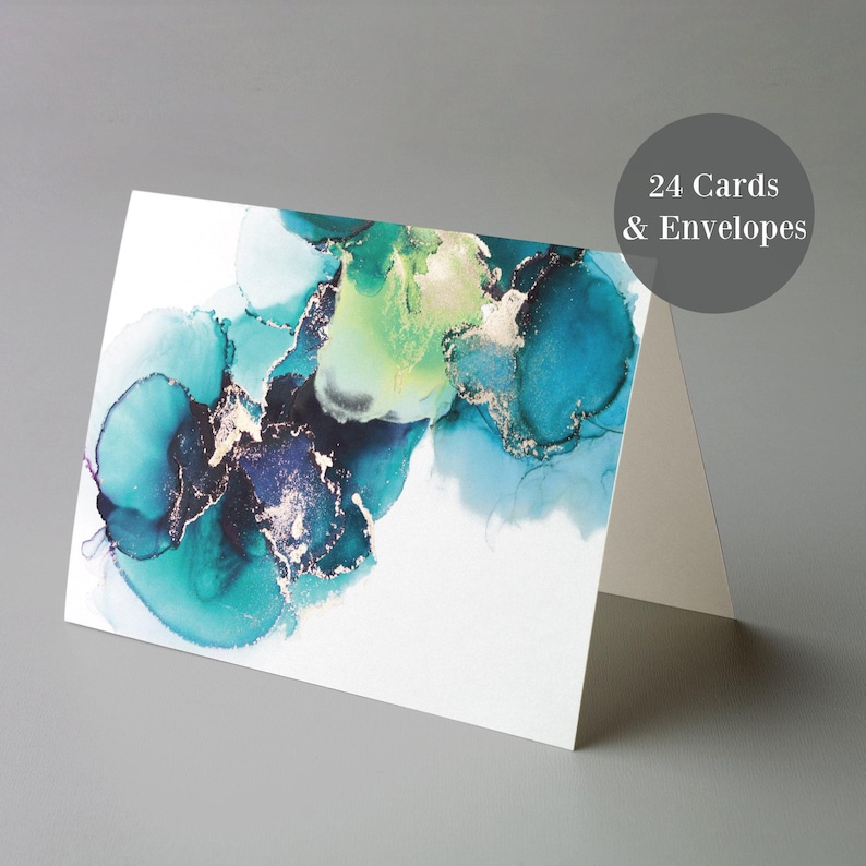 a white card with a colorful abstract design, including shades of blue, green, and gold. The card is displayed on a gray surface, and there is a text overlay that reads "24 Cards & Envelopes".