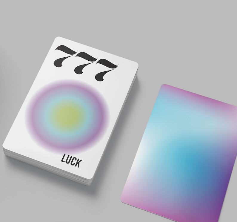 May include: A white card with the number 777 printed in black. The card has a gradient circle in shades of purple, blue, and yellow. The word "LUCK" is printed in black at the bottom of the card.