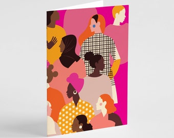 May include: A folded greeting card featuring a vibrant, flat-style illustration of a diverse group of people. The artwork uses a bold color palette of hot pink, orange, yellow, and black, showcasing various hairstyles, headscarves, and patterns.