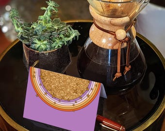 Könnte beinhalten: Eine gefaltete Grußkarte mit violettem Hintergrund, einem goldglitzernden Halbkreis und konzentrischen orangefarbenen, gelben und weißen Bögen, die mit kleinen goldenen Sternen verziert sind. Eine Glaskaraffe mit Holzkragen und eine Sukkulente.