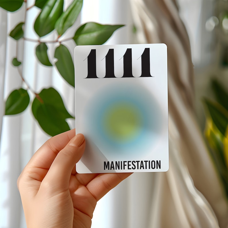 May include: White card with the number 1111 printed in black bold font. The card has a blue and yellow gradient circle in the center and the word "MANIFESTATION" printed in black at the bottom.