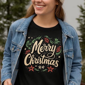 May include: Black t-shirt with a festive "Merry Christmas" design. The design features a wreath of green leaves and red berries, with the text in a cream-colored script. Red and green stars are at the bottom of the design.