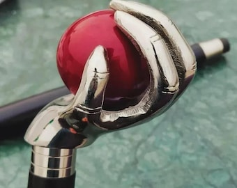 Bastón de estilo victoriano con empuñadura de bola, fuste de madera negra y diseño plegable.