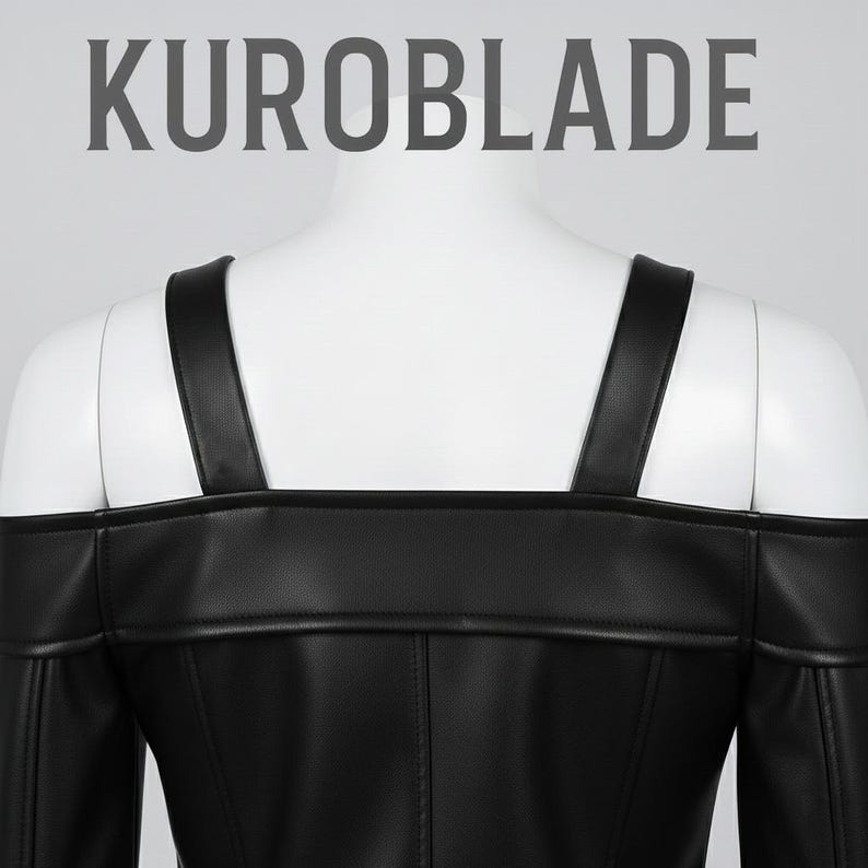 May include: Black off-the-shoulder top with shoulder straps. The top is made of a smooth, dark material and features the text "KUROBLADE" at the top. The garment is displayed on a white mannequin.