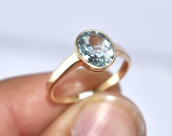 Anillo de aguamarina con brillo natural en oro macizo de 14 quilates. Engaste de bisel de piedra preciosa azul ovalada. Piedra natal de marzo. Joya moderna de reliquia.
