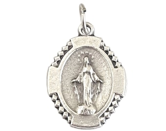 Könnte beinhalten: Silberfarbener Anhänger mit ovalem Mittelteil, das eine religiöse Figur mit ausgestreckten Armen zeigt. Der Anhänger hat einen dekorativen Rand und eine kleine Schlaufe für eine Kette.