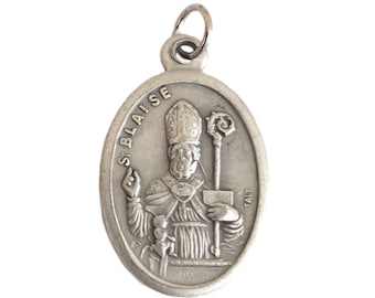 May include: Silver oval pendant with a depiction of Saint Blaise, a Catholic saint, wearing a mitre and holding a crosier and a chalice. The pendant has the text "St Blaise" inscribed on it.