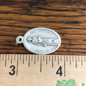 St Joseph the Worker Catholic Medals next to ruler for size
