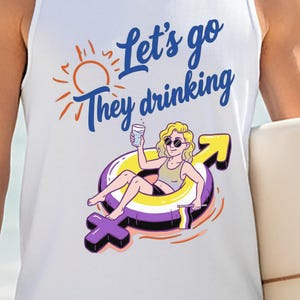 Könnte beinhalten: Weißes Tanktop mit dem Text "Let's go They drinking" in Blau und Orange. Die Grafik zeigt eine Cartoon-Person in einem Pool-Floatie mit einem Getränk. Ein Surfbrett wird in der rechten Hand gehalten.