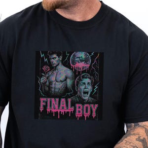 Peut inclure: T-shirt noir avec un motif "FINAL BOY". Le motif comprend deux personnages masculins, une boule disco et des éclairs. Le texte est rose avec un effet dégoulinant. Un vêtement décontracté.