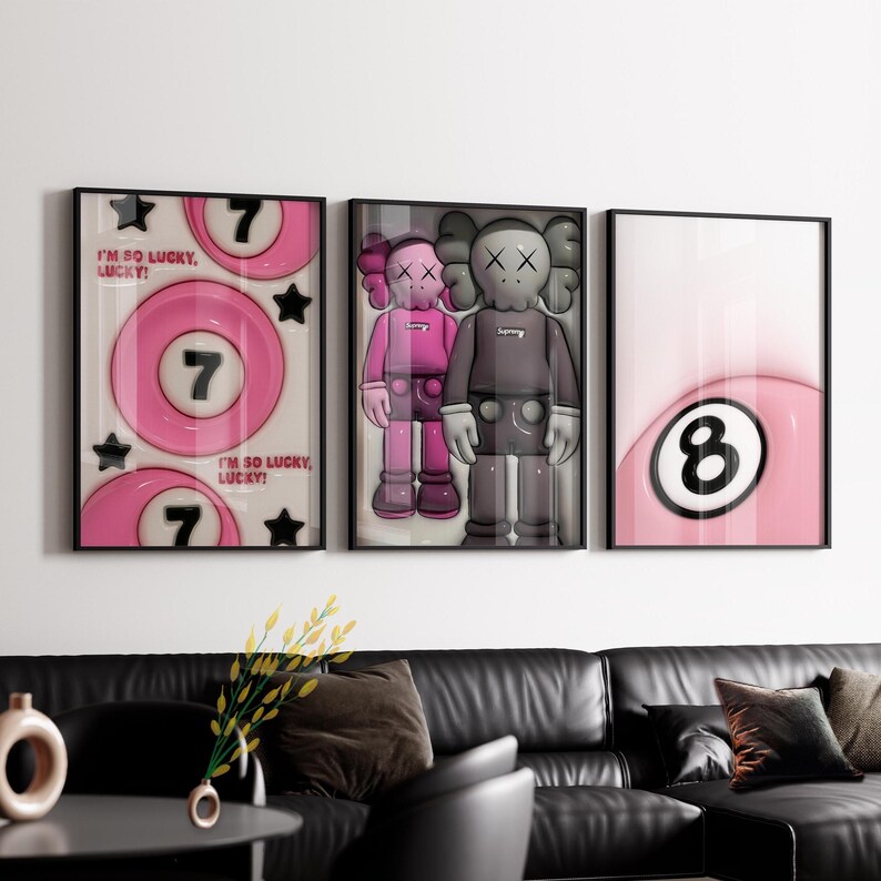 May include: Three framed art prints. The left print features a pink pool ball with the number 7 and the text "I'M SO LUCKY, LUCKY!". The center print shows two cartoon figures. The right print displays a pink pool ball with the number 8.