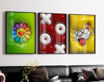 May include: Three framed art prints. The first features a colorful smiling flower on a green background. The second has white X's and O's on a red background. The third shows a cartoon cup with crossed-out eyes and a lolling tongue on a yellow background.