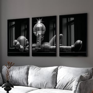 May include: Monochrome triptych art print depicting a figure with a disco ball. The artwork is set against a dark backdrop, with the figure's form detailed with a textured pattern. The art is framed in black.