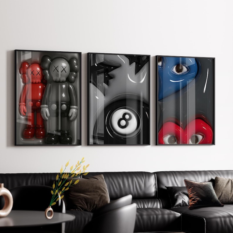May include: Three framed art pieces. The left frame features two red and gray figures. The center frame shows a black and white eight ball. The right frame displays a blue and red heart with eyes.