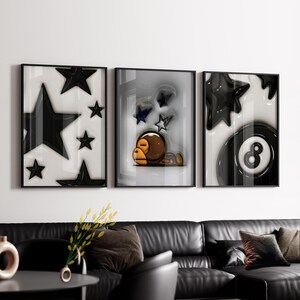 May include: A triptych of framed art prints. The first shows glossy black stars on a white backdrop. The second features a cartoon character with stars. The third depicts a black eight-ball and stars on a white background.