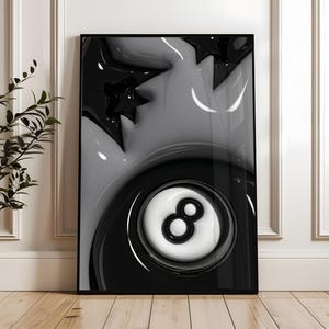 May include: Black and white framed art print featuring a glossy, abstract design. The artwork includes a stylized eight ball, stars, and flowing shapes. The color palette is limited to black, white, and shades of gray, creating a modern aesthetic.