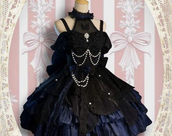 Op de afbeelding: Zwarte en marineblauwe Lolita-jurk met ingewikkeld kant en parelaccenten. De jurk heeft een gelaagde rok, off-the-shoulder mouwen en een hoge kraag. Een decoratieve broche en de tekst "TDH" zijn zichtbaar.