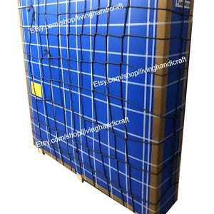 May include: A large, rectangular package wrapped in blue and brown cardboard. The package is secured with a black net and white tape. The text "Etsy.com/shop/livinghandicraft" is visible on the package.