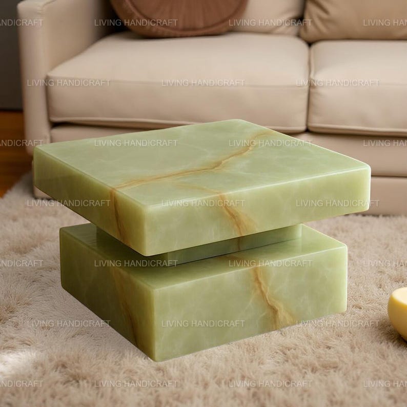 May include: A modern, two-tiered coffee table made of light green onyx. The rectangular top and base are connected by a central support. The onyx has natural brown veining, adding to its unique appearance. The table is set on a plush, light-colored rug.