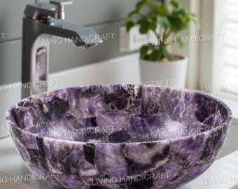 May include: Oval-shaped amethyst stone sink with a polished finish. The sink features a mosaic pattern of purple and black hues. A modern chrome faucet is visible in the background, along with a small potted plant.
