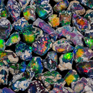 May include: A close-up of a collection of raw opals. The opals exhibit a play of colour, with flashes of green, blue, orange, and red. The rough stones are of varying sizes and shapes, set against a dark backdrop, highlighting their natural textures.