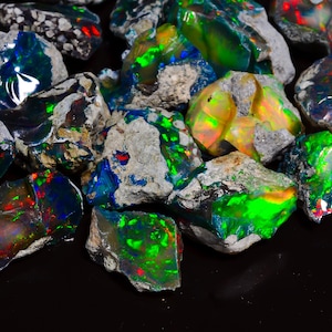 Puede incluir: Una colecci&oacute;n de &oacute;palos en bruto sin cortar. Los &oacute;palos exhiben un vibrante juego de colores, con destellos de verde, azul, rojo y amarillo. Las piedras se colocan sobre un fondo oscuro, resaltando su belleza natural. Los &oacute;palos son de varios tama&ntilde;os y formas.