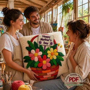 May include: A cream-colored pillow with a floral basket design. The basket is filled with red, pink, and yellow flowers. The pillow has a sign that reads "Happy Mother's Day". The image shows a punch needle pattern with 4 different sizes.